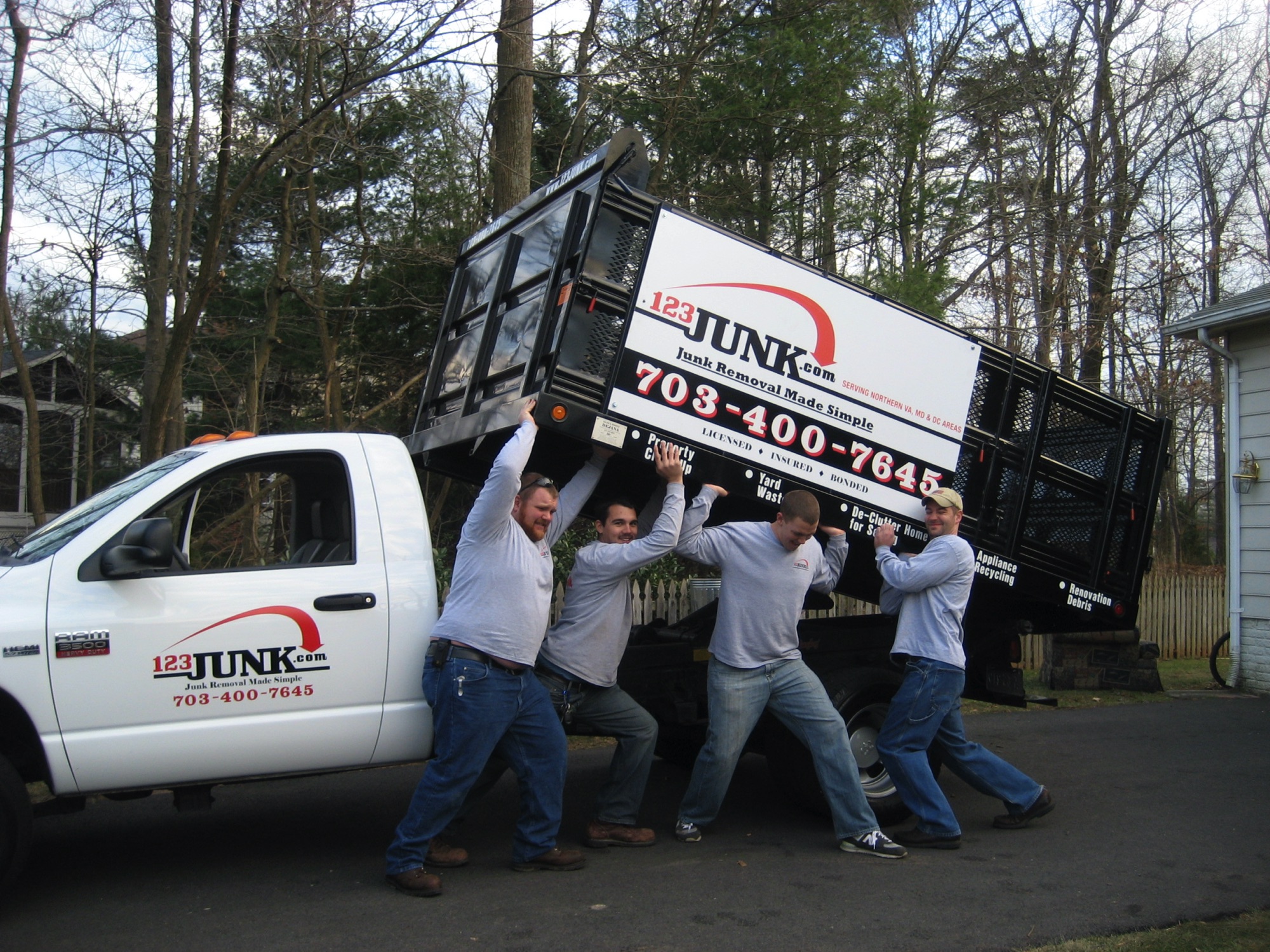 four men pretending to lift the back of work moving truck