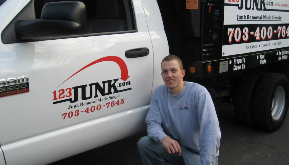 man kneeling next to company moving truck