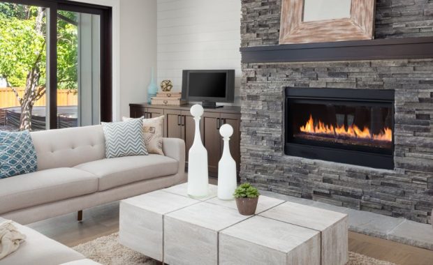 Modern living room with sofas, coffee table, and stone fireplace