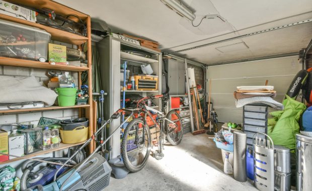A garage with bicycles and tools, divided into four labeled zones on the floor for decluttering