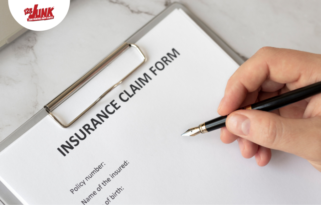 Close-up of a hand holding a pen over an insurance claim form on a clipboard