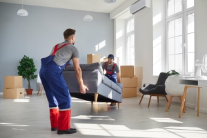Junk Removal Workers Lifting Old Sofa from A House