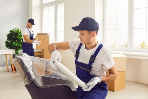 Worker Wrapping Furniture and Packing Clutter for Removal