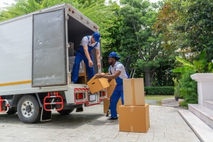 Junk Removal Workers Loading Boxes Into A Truck for Downsizing A House