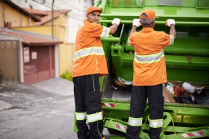 Junk Removal Workers Standing on Dump Truck for Trash Collection