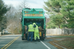Junk Removal Workers Loading Trash into Truck on Residential Street