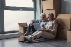Senior Couple on Laptop Making List of Items for Donation and Recycle for Downsizing