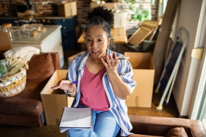 Senior Woman Making Home Downsizing Checklist on Phone