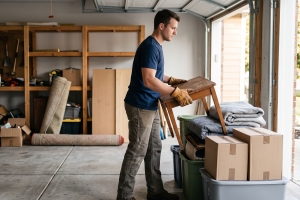 Property Cleanout Worker Sorting Items Beside Open Shelves in a Garage