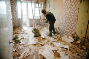 Worker Cleaning Clutter from an Apartment